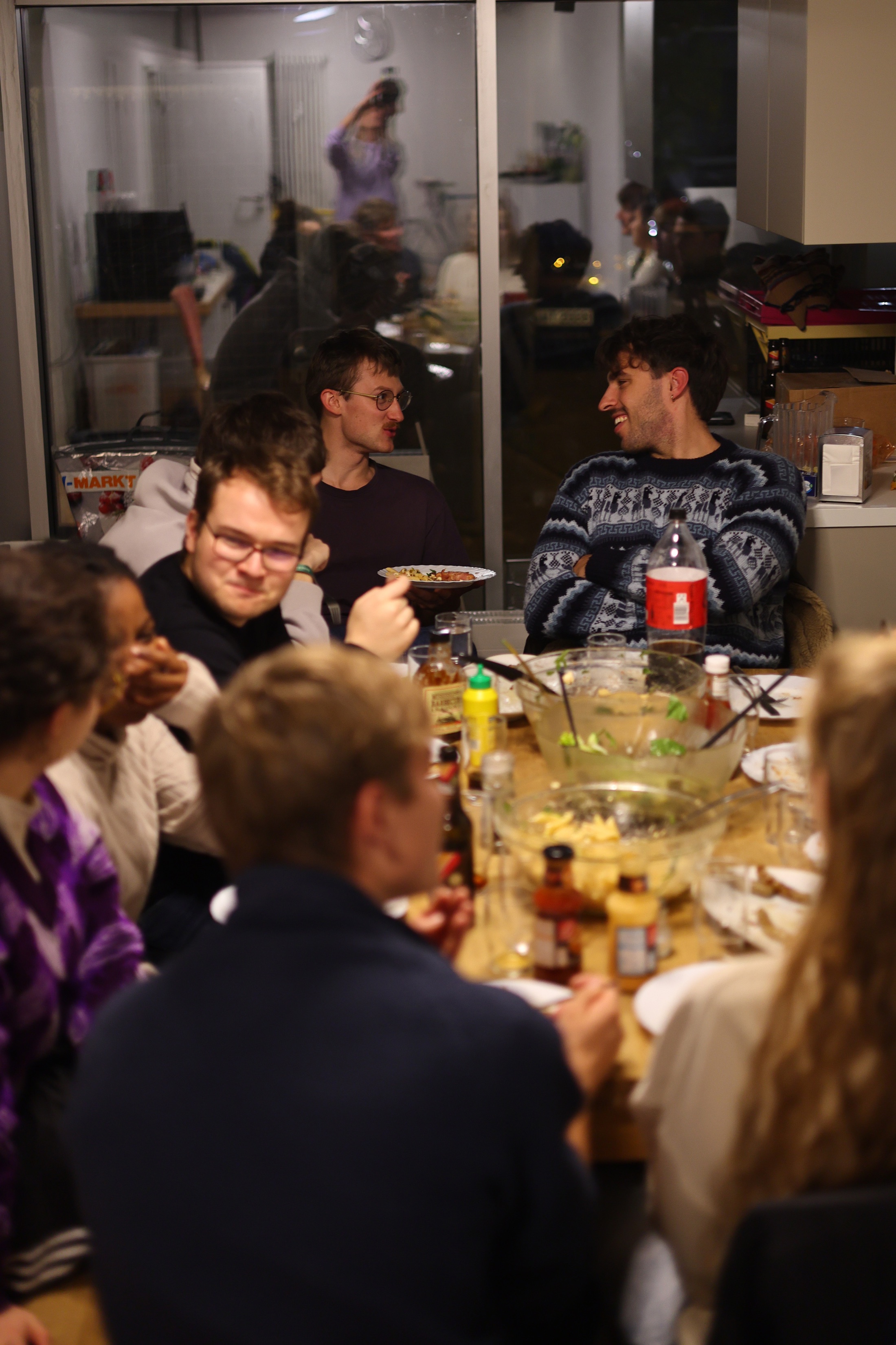 Junge Erwachsene sitzen gemeinsam an einem Tisch und essen.