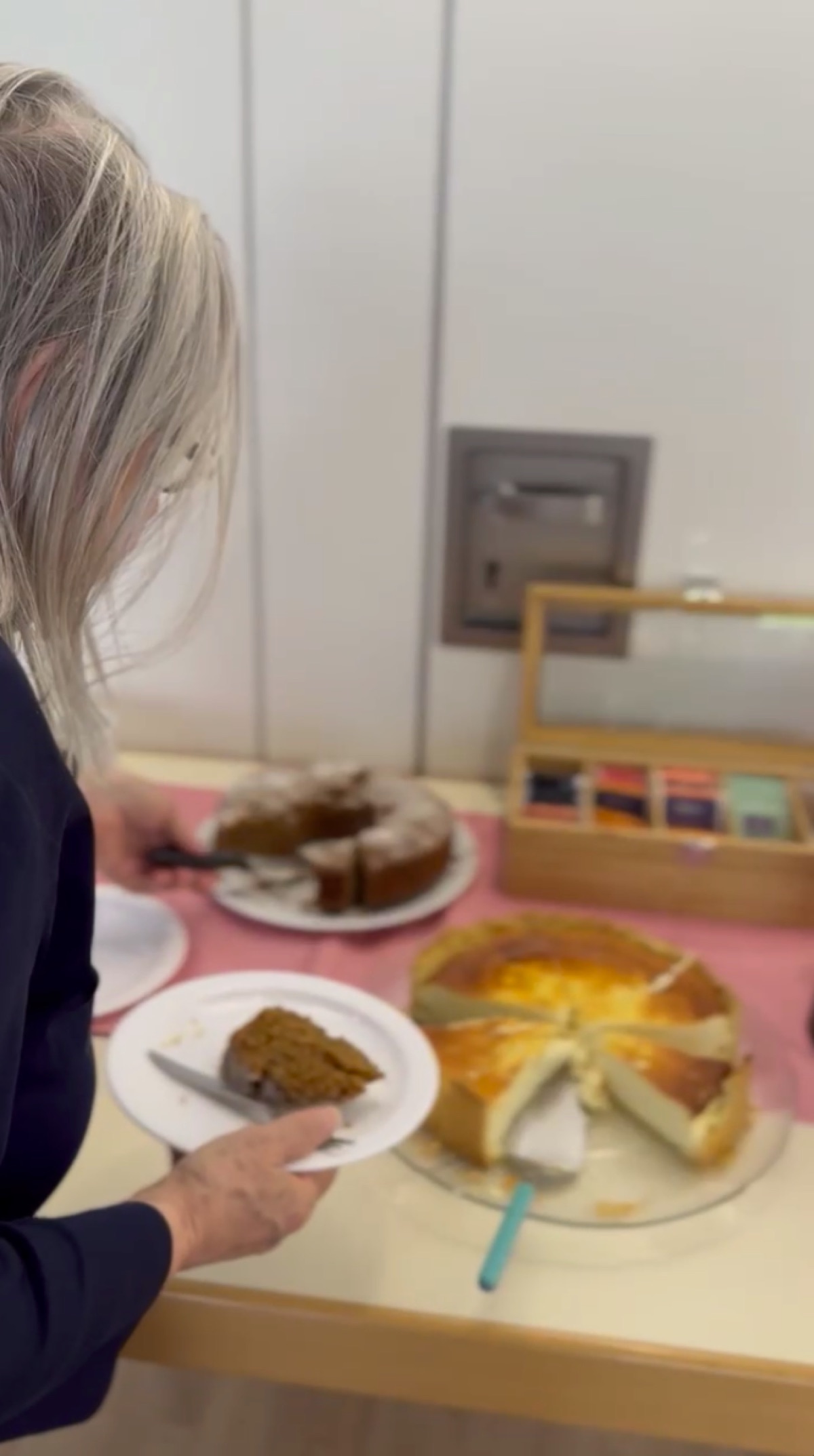 Eine Person nimmt sich Kuchen vom Buffet.