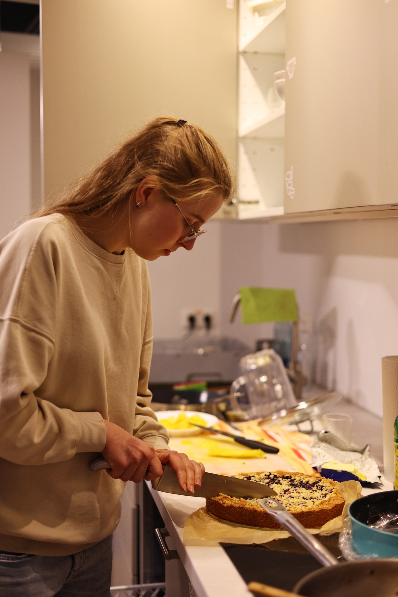 Eine Person schneidet Kuchen in der Küche an.