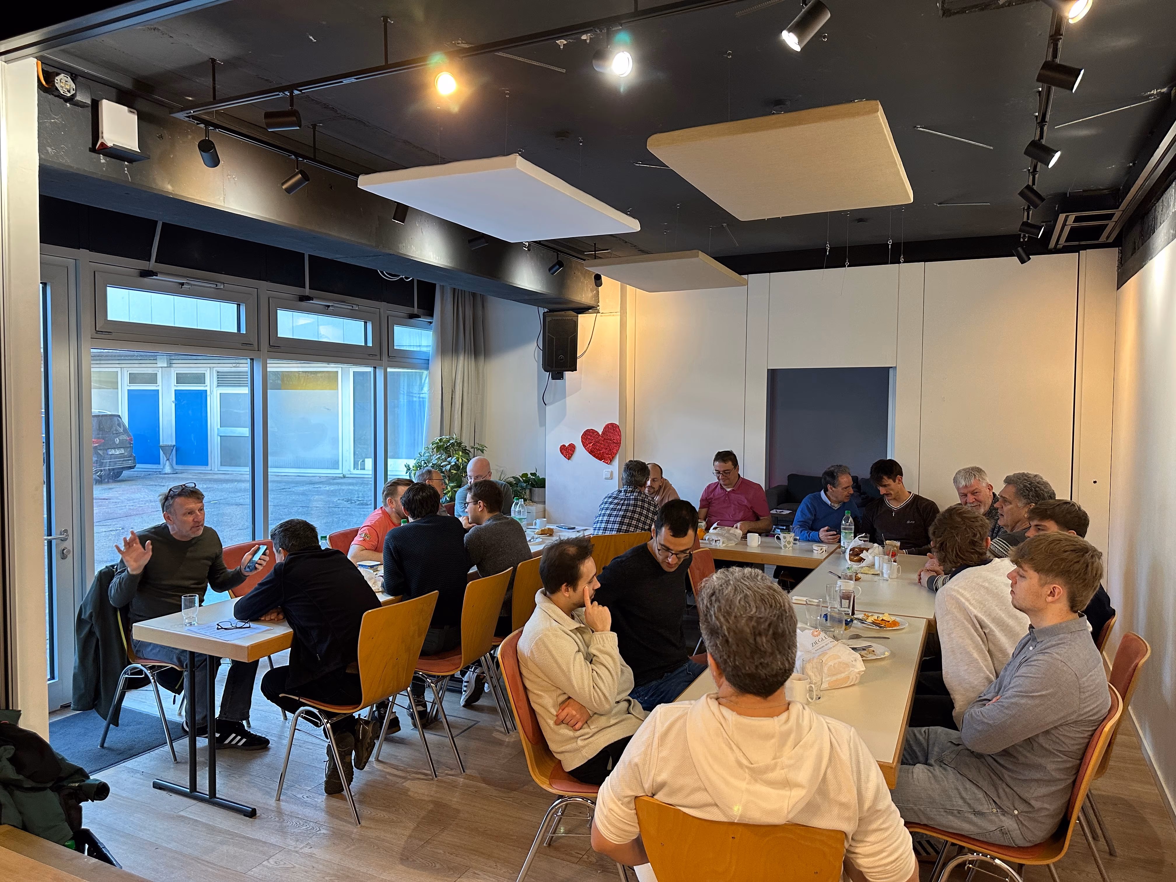 Männer sitzen gemeinsam an Tischen beim Frühstück.